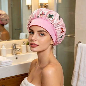 Detail of pink satin sleep cap with butterfly print and wide elastic band on model