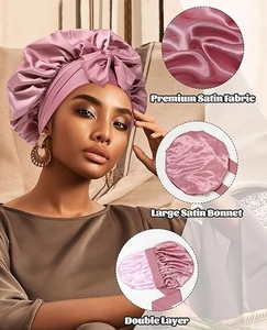 Detail showing premium double-layer satin fabric and large bow design on pink bonnet