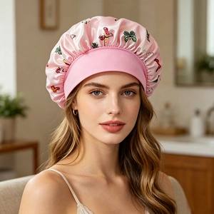 Detail of pink satin sleep cap with butterfly print and elastic wide band for hair care