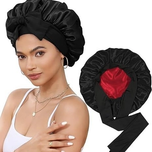Detail of double-layer satin sleep bonnet featuring black silk texture and red inner lining