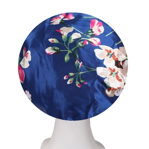 Detailed texture of dark blue floral satin sleep bonnet with wide elastic band on mannequin