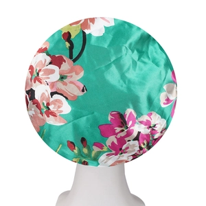 Detail of teal floral satin bonnet for hair protection on a white display head