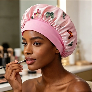Detailed view of pink satin sleep bonnet with butterfly print and elastic wide headband