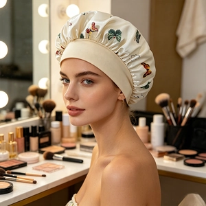 Detail of the butterfly print satin sleep cap with wide elastic headband on model