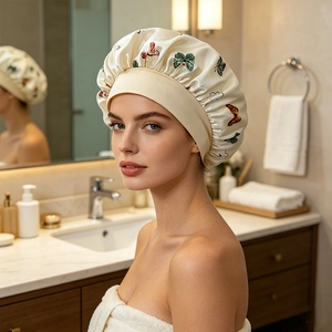 Detail of cream satin sleep bonnet with butterfly print and wide elastic band