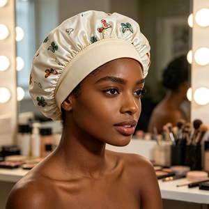 Detail of satin hair bonnet with butterfly print and elastic wide band on a model