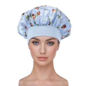 Détail du bonnet de nuit en satin bleu clair avec motifs floraux et large bande élastique