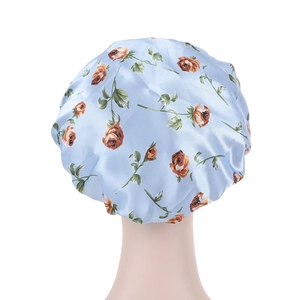 Détail d'un bonnet de nuit en satin à fleurs bleues et roses sur un mannequin de tête