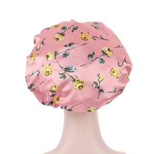 Détail du bonnet de nuit en satin rose avec imprimé floral jaune sur mannequin