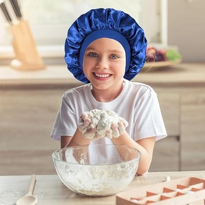 Close-up of a child wearing a dark blue satin sleep cap with a wide elastic headband