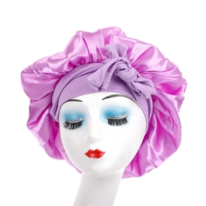Close-up of pink satin hair bonnet with purple elastic wide band and bow decoration