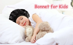Close-up of a child sleeping in a soft black satin bonnet with adjustable elastic band