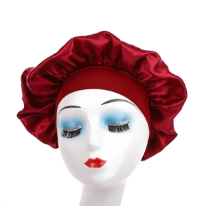 Detail of burgundy satin sleep bonnet with wide elastic band on a white mannequin head