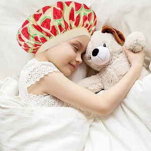 Toddler sleeping in a soft satin bonnet with cute watermelon print on white bedding