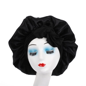 Close-up of black satin hair bonnet with wide elastic band and decorative top bow