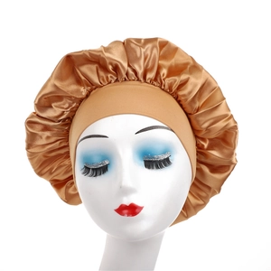 Detailed texture of champagne gold satin sleep bonnet with wide elastic headband