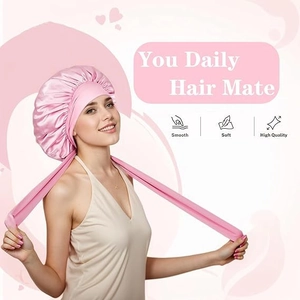 Detail of pink satin sleep bonnet with adjustable ribbon ties and smooth texture
