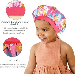 Detail of baby satin bonnet showing soft pink elastic band and floral print texture