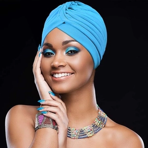 Détail d'un turban plissé bleu vif pour femmes avec collier de perles ethnique