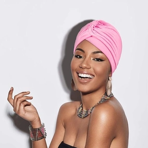 Gros plan d'un turban rose vif avec un design de nœud torsadé porté par un mannequin