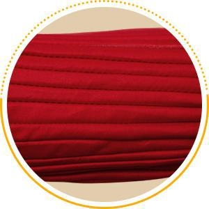 Détail du tissu plissé rouge profond et des coutures pour bonnet turban de femme
