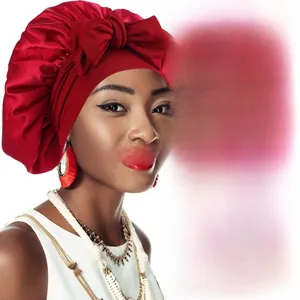 Detail of red silky satin hair bonnet with wide elastic band and large decorative bow