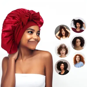 Detail of red satin sleep bonnet with large bow for curly hair protection
