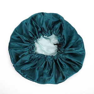 Detail of adjustable drawstring and toggle on a double-layer satin bonnet in green