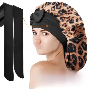 Détail de la longue sangle noire réglable sur un bonnet de nuit en soie imprimé léopard