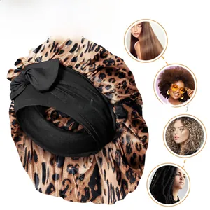 Détail du bonnet en satin léopard montrant la bande élastique et l'usage capillaire
