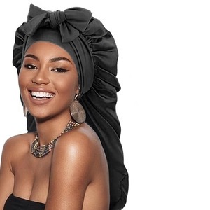 Détail d'un long bonnet de nuit en satin noir avec un grand nœud pour cheveux longs