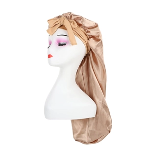 Détail du bonnet de nuit en satin doré champagne avec nœud pour la protection des cheveux