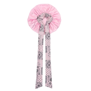 Detailed view of pink satin sleep bonnet with long paisley printed ribbon ties
