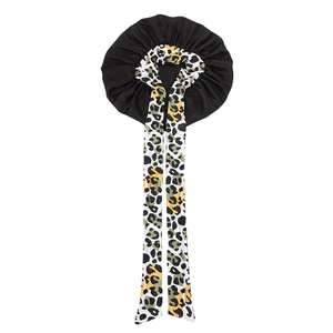 Detail of satin hair bonnet featuring leopard print long straps and black elastic fabric