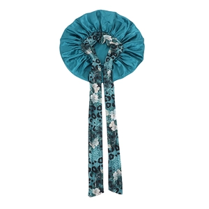 Close-up of dual-layer satin sleep bonnet with turquoise surface and floral leopard lining
