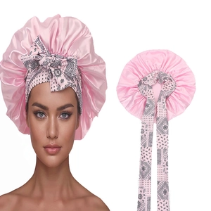 Pink satin hair bonnet with paisley print ties for women, elastic sleep cap on white background