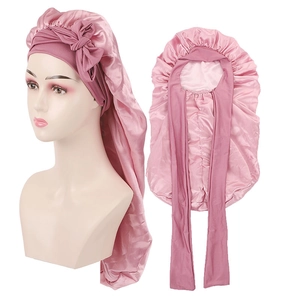 Détail du bonnet de nuit long en satin rose montrant le bandeau large et la soie