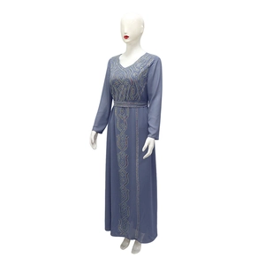 Détail de strass colorés et broderies géométriques sur la robe en mousseline gris bleu