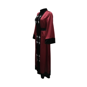 Detailed view of rhinestone floral patterns and velvet patchwork on the red satin abaya