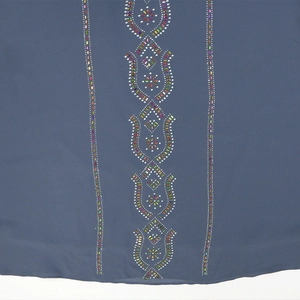 Détail d'une robe en mousseline avec des strass colorés aux motifs géométriques symétriques