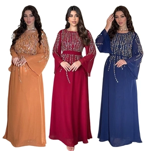 Dettaglio del ricamo in paillettes su abiti in chiffon a maniche lunghe in tre colori