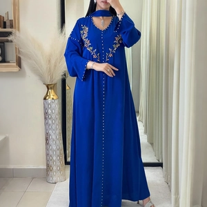 Dettaglio ricamo floreale cucito a mano e perline su abito abaya blu reale con scollo a V