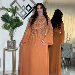 Dettaglio dell'abito lungo in chiffon corallo con nappe di paillettes e silhouette ad A