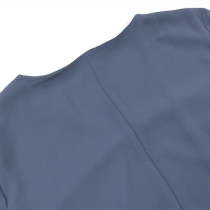 Vue détaillée de l'encolure ronde et des coutures sur une robe en mousseline bleu gris