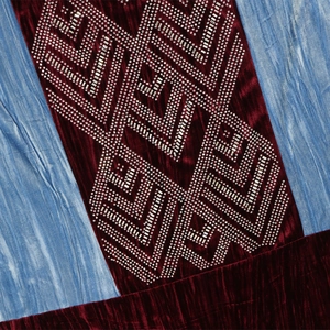 Close-up of velvet fabric with intricate rhinestone patterns and sequin embroidery