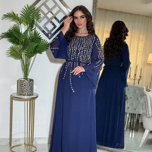 Dettaglio abito da sera in chiffon blu scuro con strass e maniche a campana su modella