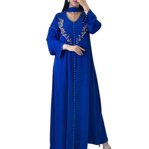 Dettaglio di perline cucite a mano e ricami floreali su un abito abaya blu scuro