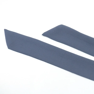 Détail de la ceinture en mousseline bleu-gris foncé avec bords coupés en diagonale nette