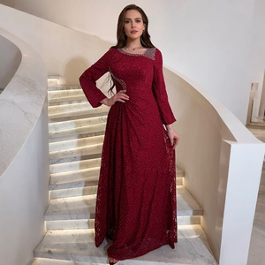 Detail of the intricate lace fabric and sparkling rhinestone accents on a burgundy gown