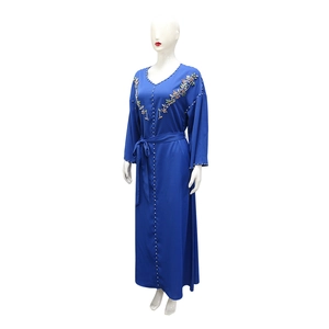 Dettaglio dello scollo a V con perline e ricami floreali sull'abito lungo tipo abaya